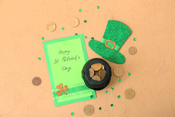 Leprechaun pot with golden coins, paper hat and card on beige background. St. Patrick's Day celebration
