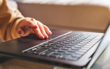 Closeup image of a hand working and touching on laptop computer touchpad at home