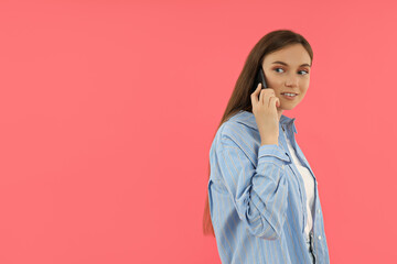 Fototapeta premium An attractive young girl holds a smartphone in her hands