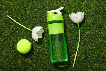 Green bottle for water, with flowers on a green background.