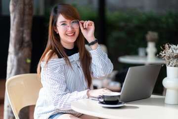 asian freelance people business female talking making using casual working with laptop computer for browsing internet, chatting and blogging and smartphone,notebook in coffee shop.