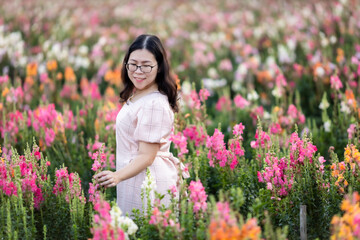 Portrait of asian Young woman happy traveler with white dress enjoying in white blooming or purple Michaelmas Daisy flower field in the nature garden of in Chiang Mai,Thailand,travel relax vacation