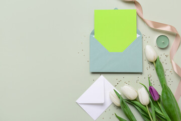 Envelopes with blank card and tulip flowers on grey background. International Women's Day...