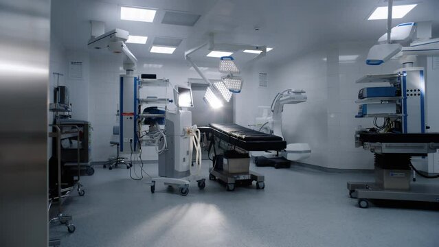 Dolly shot of operating room in modern hospital with advanced equipment for surgery. Operating table, LED lamps, life support and anesthesia machine. Operation block in clinic or medical facility.