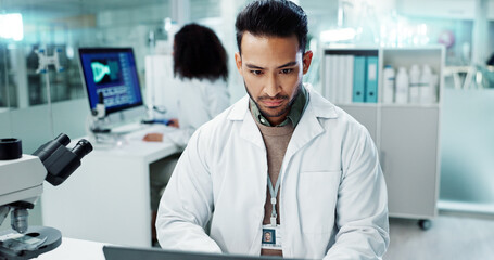 Scientist, man and reading computer for laboratory test, typing report or medical results of DNA at...