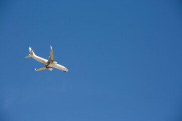 White plane is landing against a background of clear blue sky. Landing of a large aircraft in Egypt