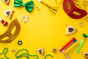 Purim holiday spirit captured. Overhead image showing filled triangle cookies, Star of David motifs, party masks, bow tie, decorative beads, and loud gragger on sunny yellow canvas, with area for text - obrazy, fototapety, plakaty