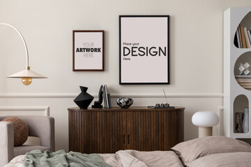 Warm and cozy bedroom interior with mock up poster frame, bed, beige bedding, stylish lamp, wooden sideboard, gray armchair, sculpture, modern rack and personal accessories. Home decor. Template.