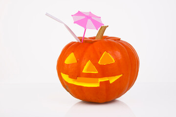 Orange pumpkin with glowing eyes, nose and mouth, cocktail pipe and cocktail umbrella, sunshade on a white background. halloween