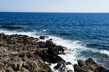 Fototapeta na wymiar Sea coast with dark stones, landscape