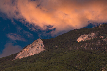 Landscape, sunset in the mountains, pink cumulus clouds over the top of the mountain. selective focus