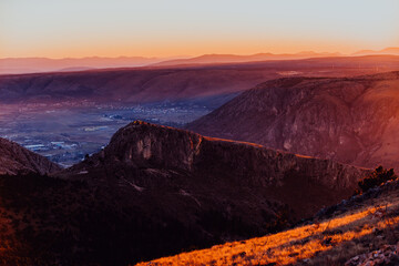 Obraz premium Capturing the breathtaking beauty of a vibrant orange and purple sunset over a majestic mountain during a serene summer evening