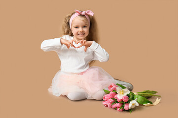 Cute little girl with bouquet of beautiful tulips showing heart gesture on brown background. International Women's Day