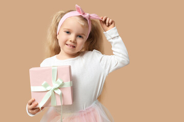 Cute little girl with gift boxes on brown background. International Women's Day
