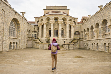 A female traveler with a backpack on her back inspects the attraction in Essentuki, the Semashko...