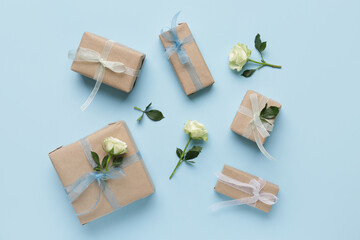 Fototapeta na wymiar Gift boxes with beautiful white roses on blue background. International Women's Day