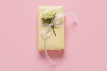 Gift box with beautiful white rose on pink background. International Women's Day