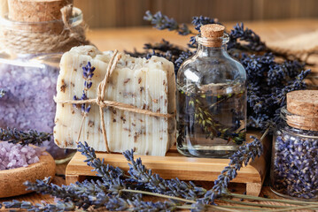 Wellness treatments with lavender flowers on wooden table. Spa still-life. Essential oils, sea salt and handmade soap. Natural herb cosmetic with lavender flowers