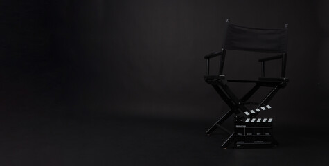 Black director chair and Clapper board on black background.