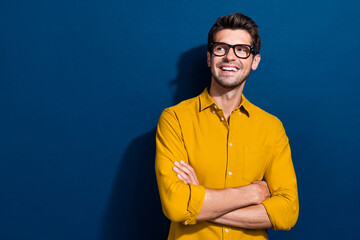 Photo portrait of attractive young man look minded empty space specs wear trendy yellow clothes isolated on dark blue color background