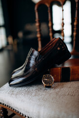 men's accessories of the groom are black leather shoes and a watch