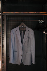 a suit hanging on a rack in a closet