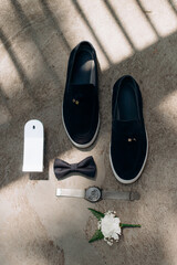 men's accessories of the groom black leather shoes, a watch, perfume and two wedding rings