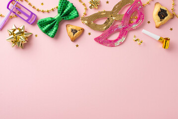 Fototapeta na wymiar Top view perspective of Purim celebration elements, including triangle-filled cookies, party masks, beads, confetti, blower, gragger, neatly arranged on pastel pink surface, space for inscription