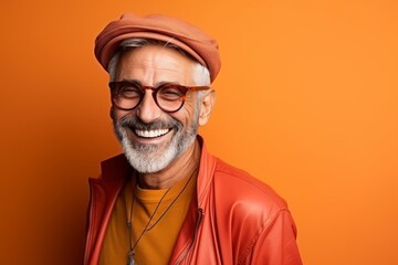 Portrait of a senior hipster man on a orange background.