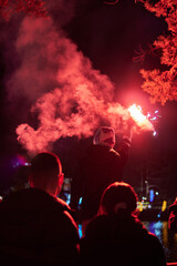 Fototapeta na wymiar Man holding red torch with smoke to celebrate