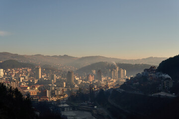 View of the city of Uzice, Serbia from fortrees above the city with sun over the buildings
