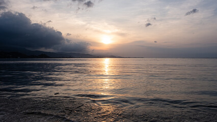Scenic landscape of golden sunset reflecting over ocean on tropical island of Timor-Leste in Southeast Asia