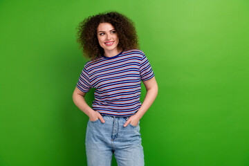 Portrait of cheerful nice girl put arms pockets toothy smile look empty space brainstorm isolated on green color background