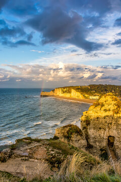 Scenic view of dramatic sunset at Etretat in Normandy in France with rainbow