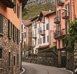 A quaint and charming medieval street in Italy. The old stone houses with colorful facades and windows line the narrow road that leads to a historic landmark. The architecture and culture of this town