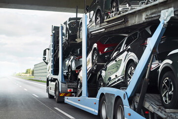 Exotic luxury sport cars with shiny performance and power are transported on a two-level hydraulic...