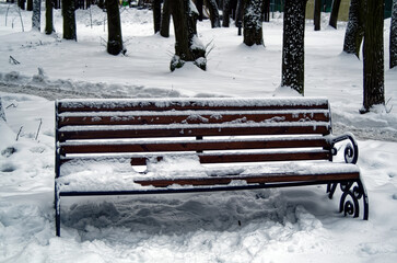 Outdoor bench in the snow in the park