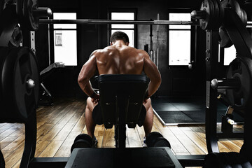 Sport motivation. gym theater. Muscular guy bodybuilder doing exercises with dumbbells in the gym....