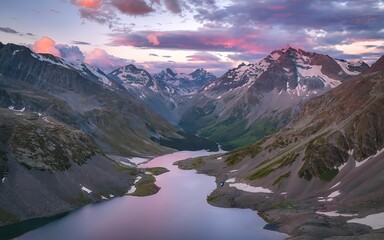 Fototapeta na wymiar Sunset in magenta tones. Glacial lake high in the mountains. Atmospheric purple landscape with a lake