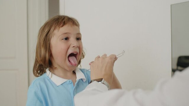 Happy echoes in therapy office: child, speech pathologist in white, learning language through play. Together, they thrive.