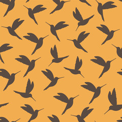 Dark grey hummingbird silhouettes on yellow background. Seamless pattern.