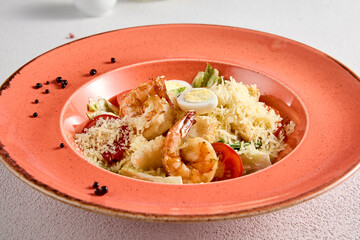 Gourmet Caesar Salad with Succulent Shrimp and Quail Eggs on a Terracotta Plate