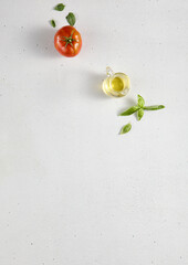 Minimalist food background with an empty white textured table, tomato, and olive oil, top view with ample copy space. Perfect for recipe books and cooking guides