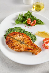 Pan-seared salmon steak with fresh spinach on white plate, perfect for healthy lifestyle and seafood cuisine presentations