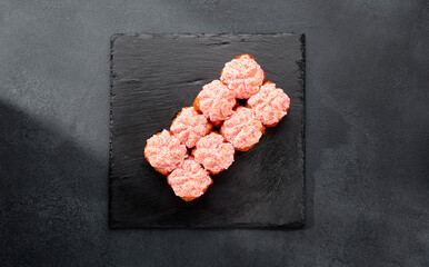 Sushi roll with tobiko caviar, topped with a creamy cheese cap and more caviar; a luxurious bite with a rich texture
