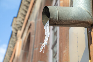Hanging icicles on the edge of the pipe.