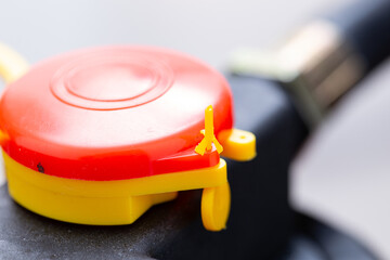 closeup of a palm button of a reusable and refillable foam fire extinguisher with a seal to prevent tampering, pull out seal of a safety device