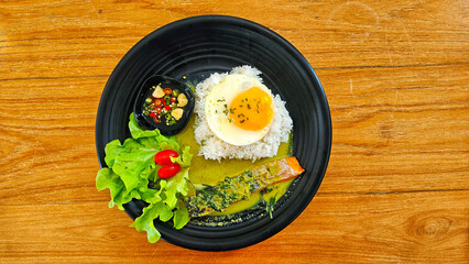 Rice with green curry salmon and fried egg, Thai cuisine style.