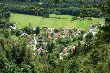 climbers in view of the charming Alpine village in the valley below the rock with Slovenian ferratesull equipment climb Slovenian ferrates
