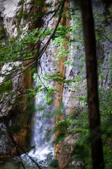 turquoise crystal clear water of a waterfall of a mountain Alpine river